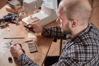 Terzi yün kumaştan papyon yapar. Tekstil atölyesinde dikiş makinesiyle çalışıyorum..