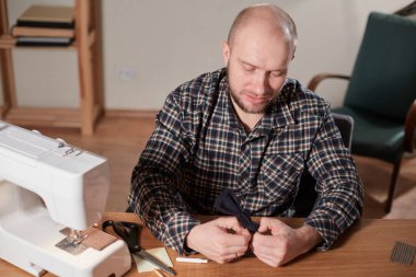 Terzi yün kumaştan papyon yapar. Tekstil atölyesinde dikiş makinesiyle çalışıyorum..