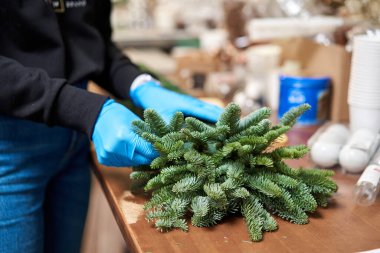 Bir kadın Noel düzenini süslüyor. Dekoratif süsler konusunda yüksek lisans. Noel dekorunu kendi elleriyle yaptılar. Yeni yıl kutlaması. Çiçekçi