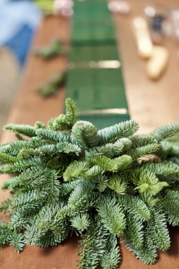 Bir kadın Noel düzenini süslüyor. Dekoratif süsler konusunda yüksek lisans. Noel dekorunu kendi elleriyle yaptılar. Yeni yıl kutlaması. Çiçekçi