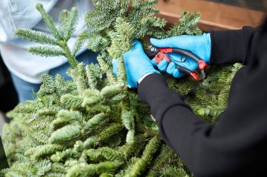 Bir kadın Noel düzenini süslüyor. Dekoratif süsler konusunda yüksek lisans. Noel dekorunu kendi elleriyle yaptılar. Yeni yıl kutlaması. Çiçekçi