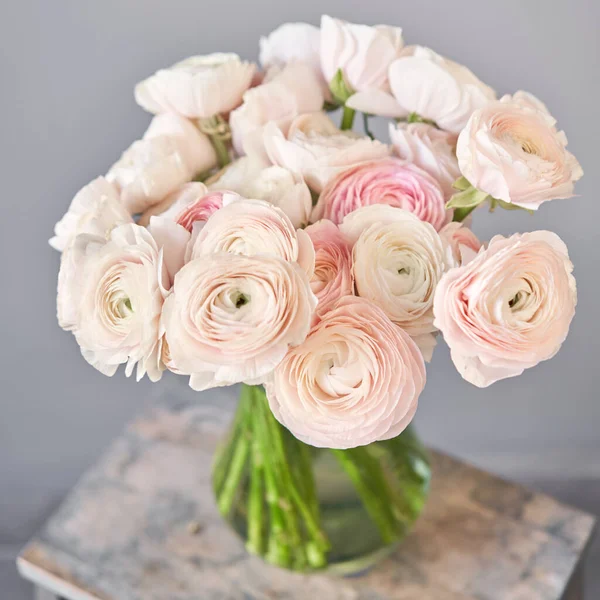 Frühling Hintergrund, Blume Tapete. Persische Butterblume. Bündel rosa Hahnenfuß-Blüten auf hellgrauem Hintergrund. Vase auf Holztisch vorhanden. Tapete — Stockfoto