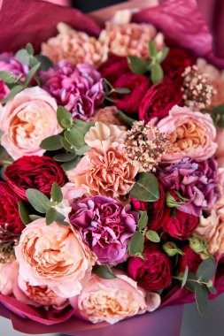 Parlak böğürtlen rengi, kadınların elinde güzel bir buket karışık çiçek. Çiçekçi dükkanındaki çiçekçinin işi. Taze kesilmiş çiçek getirdim. Avrupa Çiçek Dükkanı.