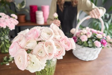 İranlı düğün çiçeği. Bir demet soluk pembe ranunculus çiçeği. Eski ahşap masadaki vazo. Çiçek dükkanı konsepti. Çiçek teslimatı.