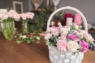 Hasır sepette çiçek aranjmanı. Çiçek dükkanı konsepti. Güzel bir buket karışık çiçek. Yakışıklılar. Çiçek teslimatı.