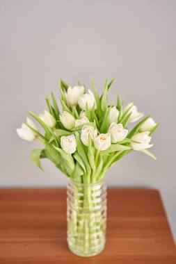 Cam vazoda beyaz renkli laleler. Çiçeklerin doğal arkaplanı. Diğerlerinin aksine sıra dışı çiçekler..