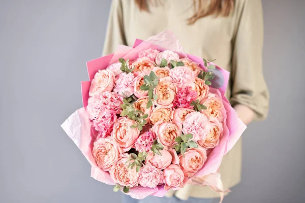 Mooi boeket van gemengde bloemen in vrouwen handen. het werk van de bloemist in een bloemenwinkel. Levering verse snijbloem. Europese bloemenwinkel. — Stockfoto