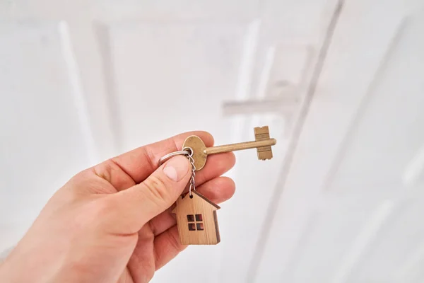 Intérieur moderne du hall lumineux. Hommes main tenant clé avec porte-clés maison. Immobilier, déménagement ou location de biens. Concept hypothécaire . — Photo