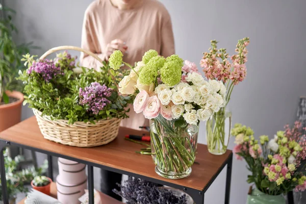 Education in the school of floristry. Master class on making bouquets. Summer bouquet in a wicker basket.. Learning flower arranging, making beautiful bouquets with your own hands. Flowers delivery