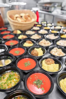 Yemek servisi. Plastik tek kullanımlık beslenme çantasında sağlıklı doğal gıdalar var. Tavuk çorbası, çorba püresi, pirzola, deniz ürünleri makarnası, salata, taze çörekle pilav..