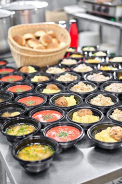 Yemek servisi. Plastik tek kullanımlık beslenme çantasında sağlıklı doğal gıdalar var. Tavuk çorbası, çorba püresi, pirzola, deniz ürünleri makarnası, salata, taze çörekle pilav..