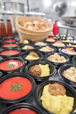 Yemek servisi. Plastik tek kullanımlık beslenme çantasında sağlıklı doğal gıdalar var. Tavuk çorbası, çorba püresi, pirzola, deniz ürünleri makarnası, salata, taze çörekle pilav..