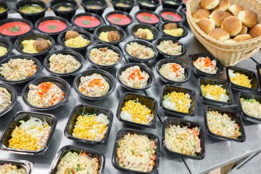 Bir sıra plastik tek kullanımlık beslenme çantası ve sağlıklı doğal yiyecekler. Çorbalar, kremalı çorba, garnitürlü ana yemek, salatalar. Yemek servisi. Ofiste öğle yemeği..