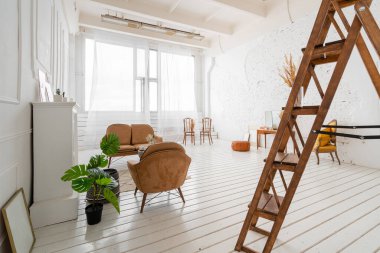 Dahili fotoğraf stüdyosu. Aydınlık bir sabah. Ahşap zemin, şömine, kanepe ve sandalyeli lüks bir oturma odasının parlak ve temiz iç tasarımı. Duvarlarda sıva