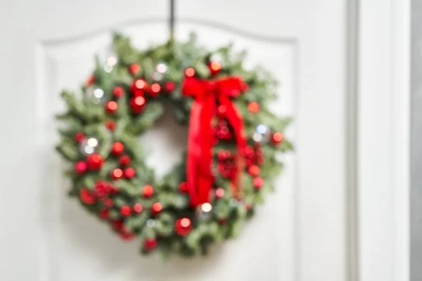 Αφηρημένη θολούρα. Κοντινές λεπτομέρειες του πανέμορφου Χριστουγεννιάτικου στεφανιού από φρέσκο έλατο στη λευκή πόρτα. Είσοδος στο σπίτι. Χριστουγεννιάτικη διάθεση. Χριστουγεννιάτικο δέντρο. — Φωτογραφία Αρχείου
