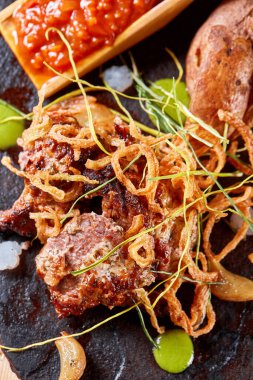 Biftekli ızgara biftek ve közlenmiş patates. Kızarmış soğan ve domates sosuyla..