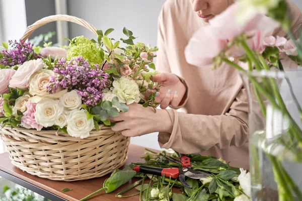 Концепція квіткового магазину. Квіткова жінка створює квіткову композицію в плетеному кошику. Прекрасний букет змішаних квітів. Гарний свіжий букет. Доставка квітів . — стокове фото