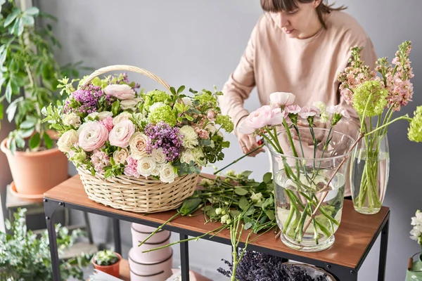 Educación en la escuela de floristería. Clase magistral en hacer ramos. Ramo de verano en una canasta de mimbre.. Aprendiendo arreglos florales, haciendo hermosos ramos con sus propias manos. Entrega de flores —  Fotos de Stock