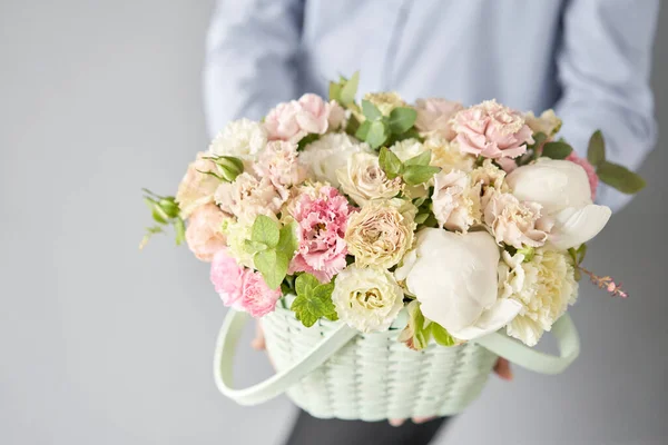 Petite boutique de fleurs et livraison de fleurs. Arrangement de fleurs dans le panier en osier. Beau bouquet de fleurs mixtes à la main de la femme. Beau bouquet frais. — Photo