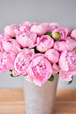 Metal vazoda pembe melek yanakları şakayıklar. Katalog ya da internet mağazası için güzel şakayık çiçekleri. Çiçek dükkanı konsepti. Taze kesilmiş güzel bir buket. Çiçek teslimatı