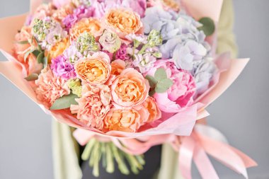 Pembe şakayıklar ve ortancalar. Kadın elinde güzel bir buket karışık çiçek. Çiçek dükkanı konsepti. Güzel, taze bir buket. Çiçek teslimatı.