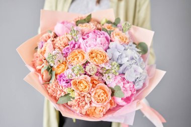 Pembe şakayıklar ve ortancalar. Kadın elinde güzel bir buket karışık çiçek. Çiçek dükkanı konsepti. Güzel, taze bir buket. Çiçek teslimatı.