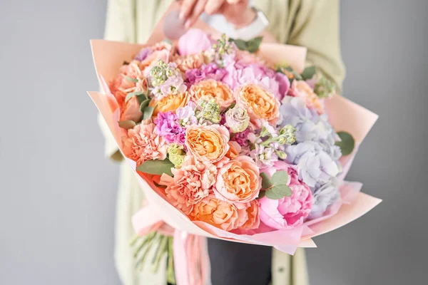 Pedónias cor-de-rosa e hortênsias. Belo buquê de flores mistas na mão da mulher. Conceito de loja floral. Bonito buquê fresco. Entrega de flores . — Fotografia de Stock