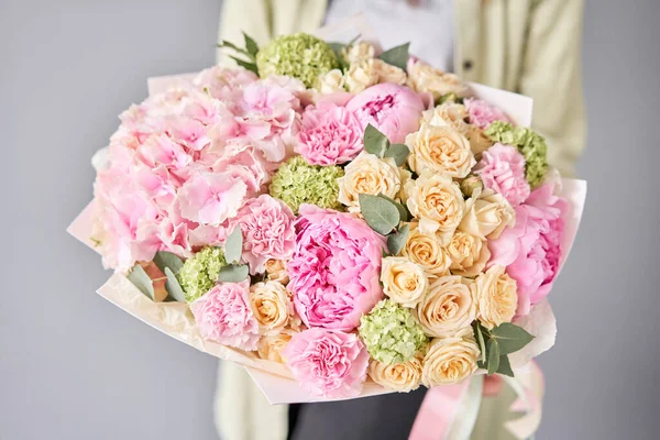Rosa pioner och hortensia. Vacker bukett av blandade blommor i kvinnlig hand. Konceptet blomsteraffär. Snygg, fräsch bukett. Blommor leverans. — Stockfoto