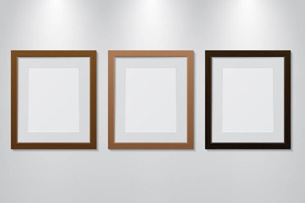 Empty wooden picture frames set on the wall with light effect