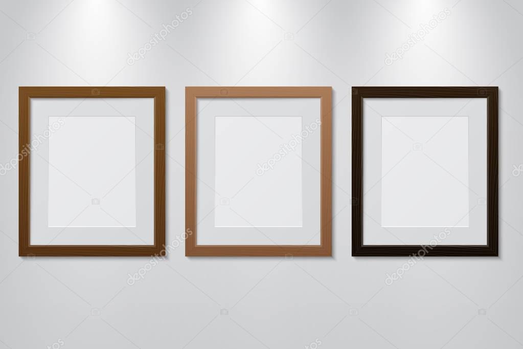 Empty wooden picture frames set on the wall with light effect