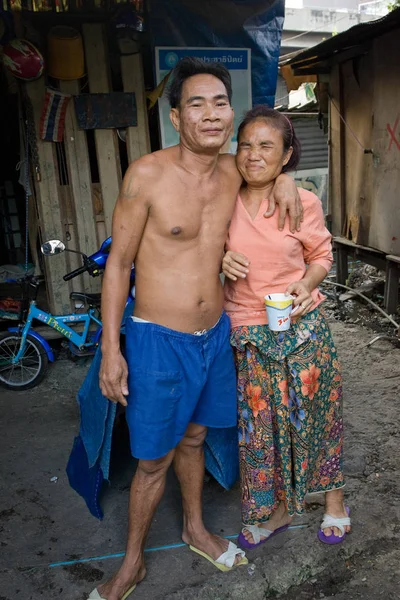 Una pareja que vive en un barrio pobre lava la ropa. — Foto de Stock