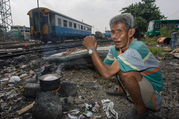 在铁路轨道附近的贫民窟，一名男子正在做饭是吃饭的客人. — 图库照片