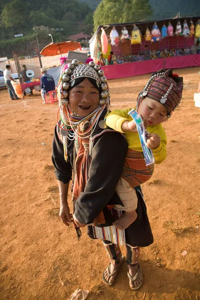 Uma mulher do grupo étnico Akha carrega seu bebê nas costas — Fotografia de Stock