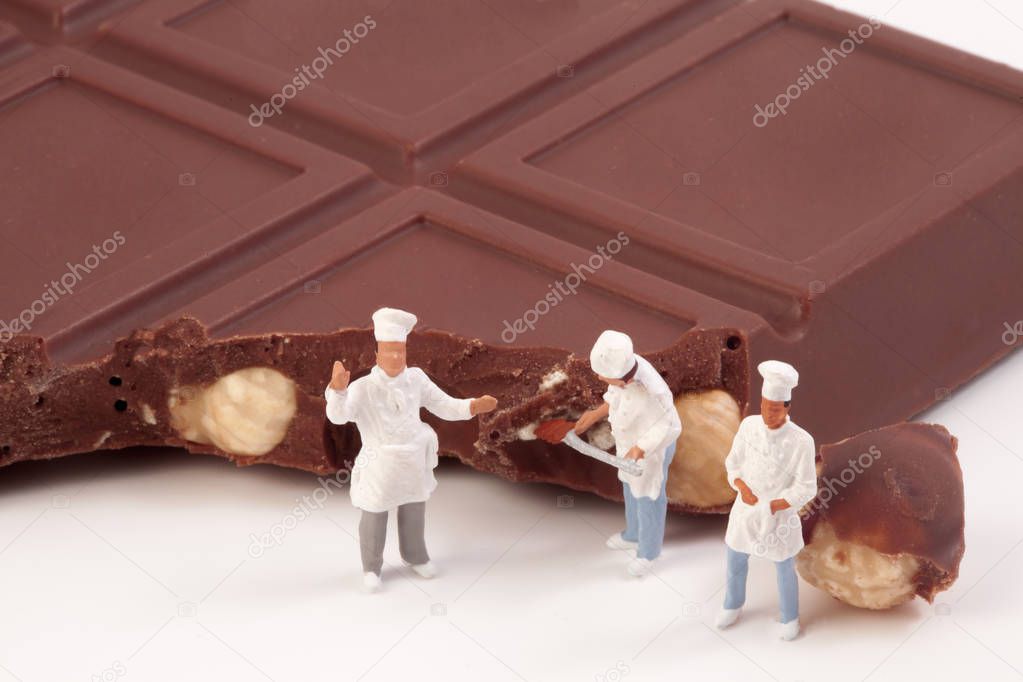 Miniature people: A chef and cooks in front of a chocolate bar