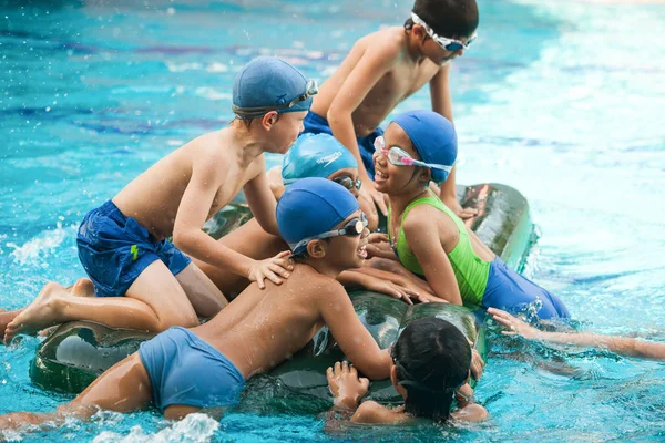 okul çocukları bir yüzme havuzunda Yüzme le sırasında eğlenin