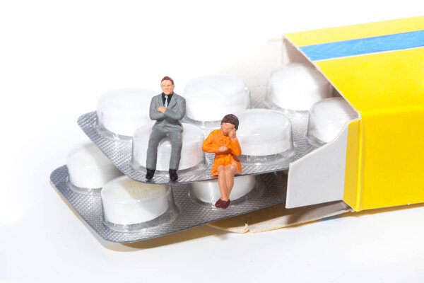 miniature people - people posing in front of pills