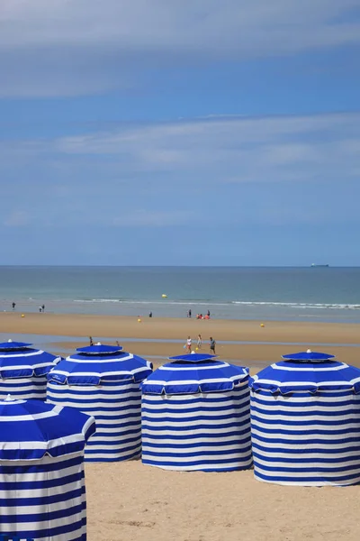 Spiaggia in estate con tende, sole e cielo azzurro — Foto Stock