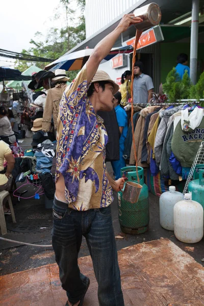 Um homem prepara um chá de leite indonésio no mercado de Chatuchak, Bangk — Fotografia de Stock
