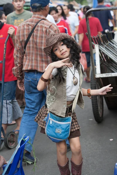 Genç bir kız şarkı söylüyor ve Chatuchak pazarı sokakta dans ediyor 