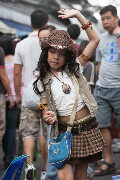 Genç bir kız şarkı söylüyor ve Chatuchak pazarı sokakta dans ediyor 