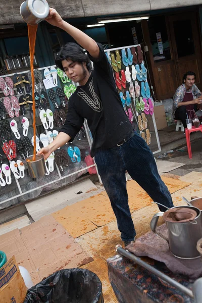 Um homem prepara um chá de leite indonésio no mercado de Chatuchak, Bangk — Fotografia de Stock