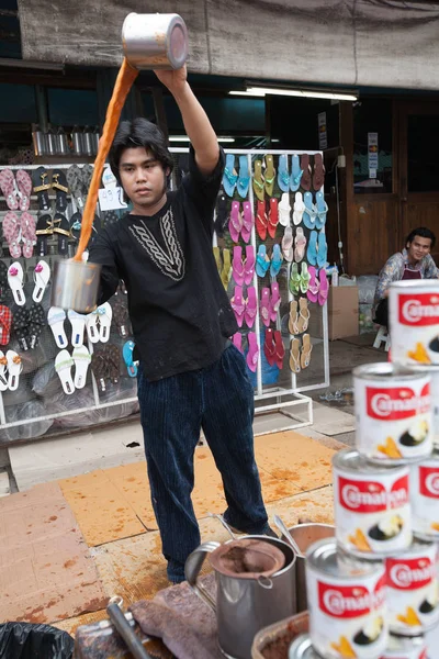 Um homem prepara um chá de leite indonésio no mercado de Chatuchak, Bangk — Fotografia de Stock