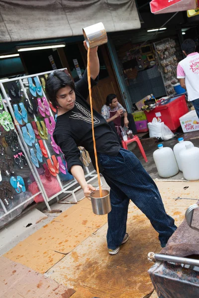 Um homem prepara um chá de leite indonésio no mercado de Chatuchak, Bangk — Fotografia de Stock