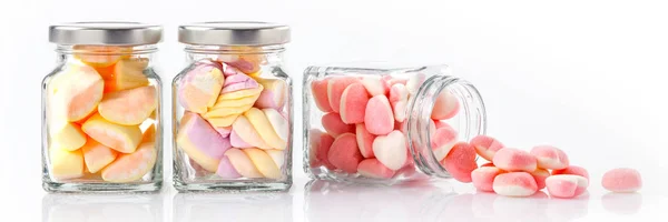 Beyaz arka planda - Web afiş gıda kavramı ile cam kavanozlara renkli şekerler
