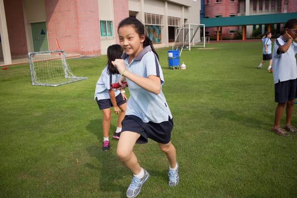 Dans un collège à Bangkok, des écoliers dans un terrain de sport en plein air — Photo