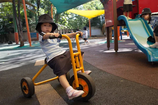 Em uma faculdade em Bangkok, as crianças se divertem no parque infantil dur — Fotografia de Stock