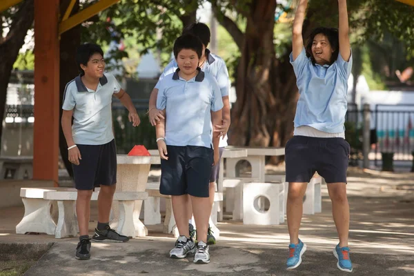 En una universidad en Bangkok, los niños se divierten en el patio de recreo — Foto de Stock