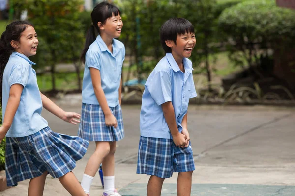 在曼谷的一所大学里, 孩子们在操场上玩得很开心。 — 图库照片