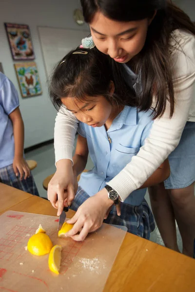 Νέοι φοιτητές λαμβάνουν ένα εισαγωγικό μάθημα στην κουζίνα με τον καθηγητή τους. — Φωτογραφία Αρχείου