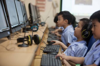 Genç okul çocukları bir bilgisayar kullanmayı öğrenmeye başlamak.